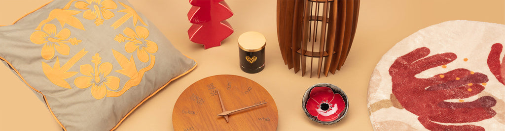 Home decor products stocked by Auckland Museum’s store including wooden te reo Māori clock, ceramic pointed leaf vase, tivaevae cushion, patterned rug and wooden lamp