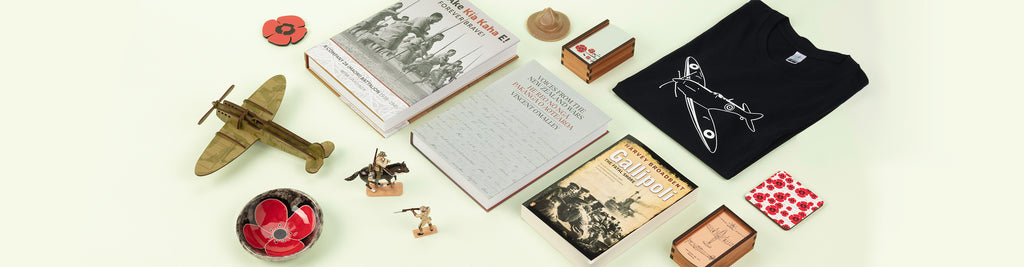 A photo showing a range of war-related products for sale at the Auckland Museum Store, including ceramic lemon squeezer hat, ceramic poppy dish, war books and a Spitfire printed t-shirt